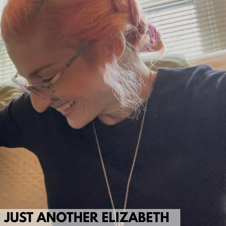 Photo of Elizabeth Mitchell / woman with peach hair and glasses, wearing a black shirt laughing and looking down to her right | an avatar of a peach haired character in a camel colored sweater is overlayed on the bottom left side of the image.